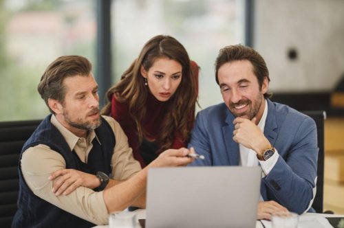 focused-team-analyzing-data-on-laptop
